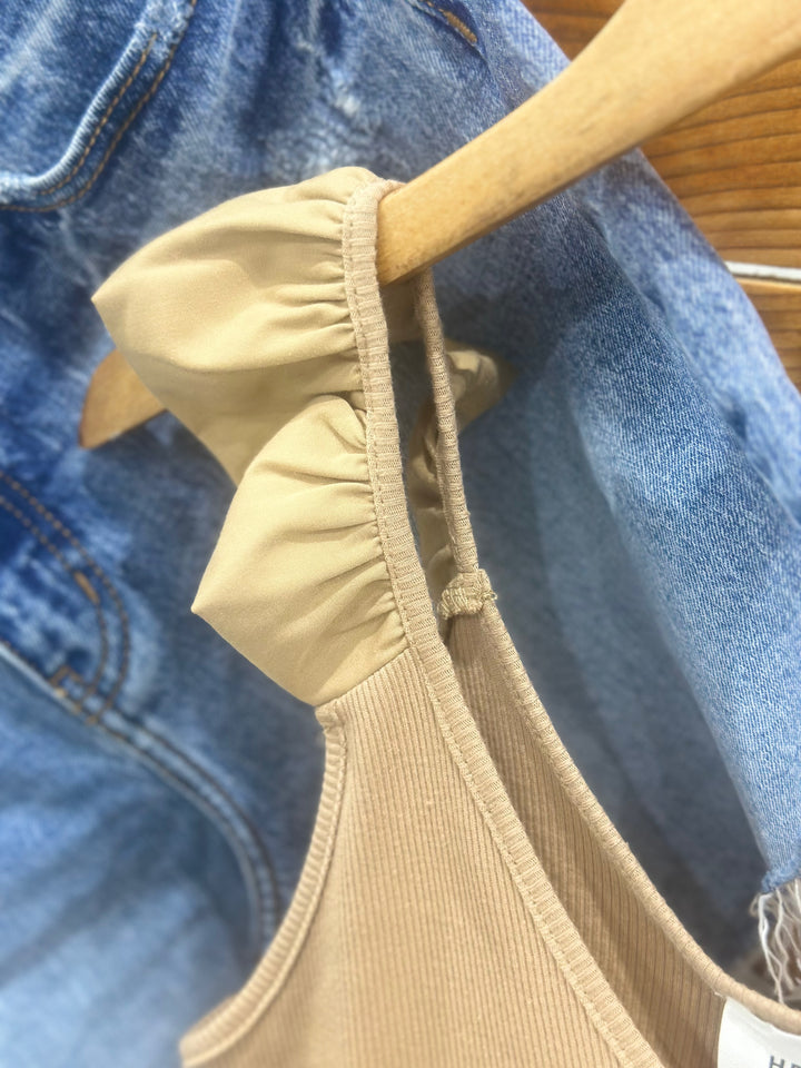 The Ashland Ruffle Tank Top in a warm mocha shade is crafted from 100% breathable cotton, offering a lightweight and comfortable feel for casual, everyday style. This women’s sleeveless blouse features delicate ruffle accents, adding a touch of femininity to a relaxed fit. Available in sizes small (2-4), medium (6-8), and large (8-10), this top is a versatile wardrobe staple, perfect for layering or wearing solo, and is comparable to tops from Madewell and Aerie.