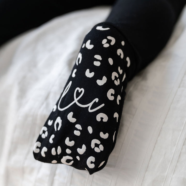 Soft and breathable black bamboo baby footie with white foot details made from eco friendly bamboo fabric that regulates temperature keeps babies cozy and comfortable and offers a modern neutral design for newborns infants and toddlers.