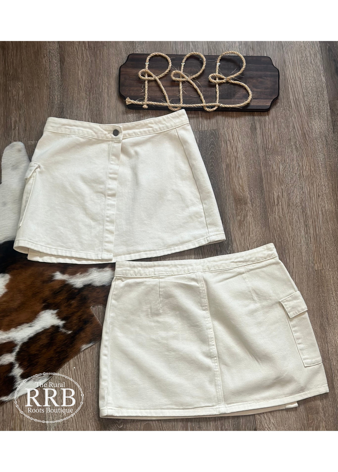 Elevate your wardrobe with The Logan Skirt in off white. This high-waisted wrap cargo mini skirt features a stylish button closure and is perfect for creating a trendy look. Crafted from a blend of 74% cotton and 26% polyester, it combines comfort and durability. Available in sizes Small (2-4), Medium (6-8), and Large (8-10), this skirt is a must-have for any fashion-forward individual.