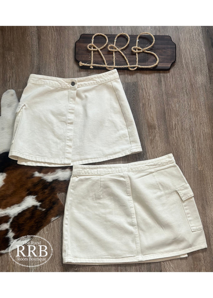Elevate your wardrobe with The Logan Skirt in off white. This high-waisted wrap cargo mini skirt features a stylish button closure and is perfect for creating a trendy look. Crafted from a blend of 74% cotton and 26% polyester, it combines comfort and durability. Available in sizes Small (2-4), Medium (6-8), and Large (8-10), this skirt is a must-have for any fashion-forward individual.