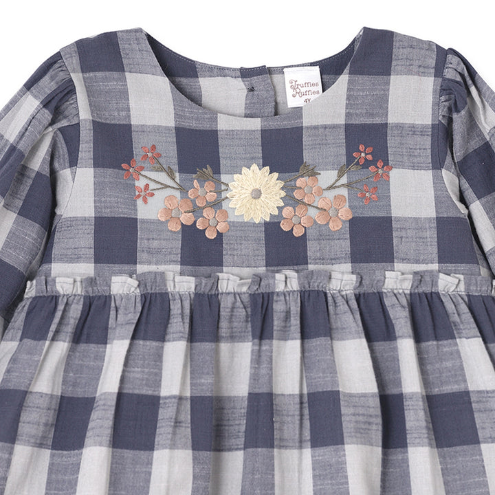 Designed for both style and ease, this woven romper brings together the best of comfort and charm. The navy and white buffalo check gives a timeless, rustic look, while colorful floral embroidery across the chest softens the silhouette with cheerful detail. An elastic waistband ensures a snug yet flexible fit, allowing for plenty of movement during playtime. Thoughtful accents—like ruffled cuffs, gentle gathers, and a vintage-inspired cut—make this piece feel special, whether dressed up for an outing 