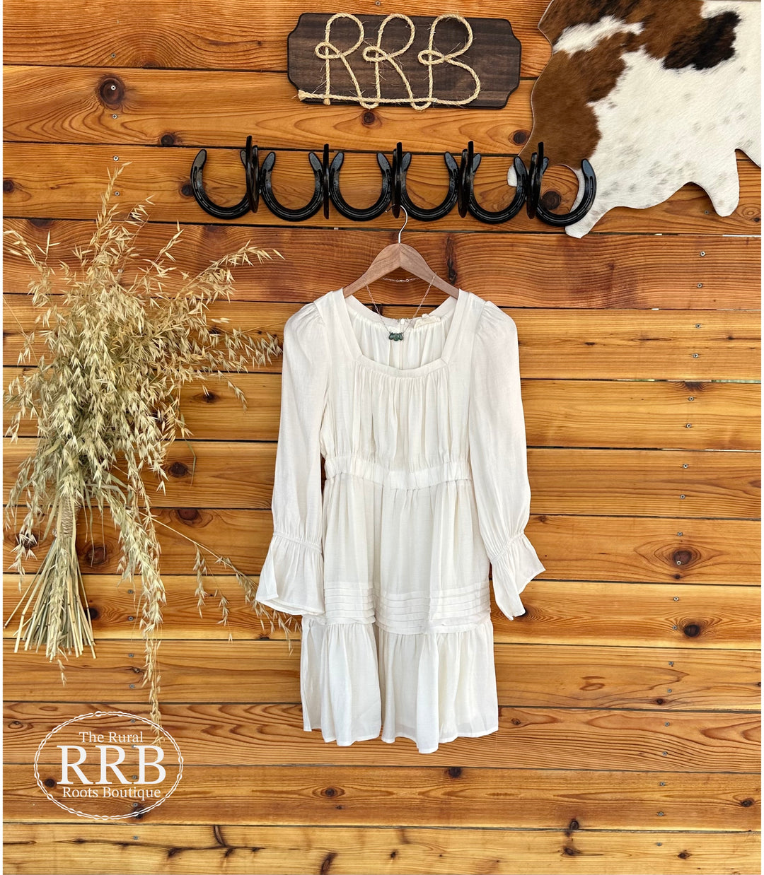 Step out in style with The Valley Dress, a cream mini woven dress featuring a square neckline and flattering ruching around the bust. The elastic waistband ensures a comfortable fit, while the pleated skirt with ruffled ends adds a playful touch. With long sleeves and an open back design, this dress is perfect for any occasion. Available in Small (3-5), Medium (6-8), and Large (9-11). Made from 80% Tencel and 20% Polyester for a soft feel.