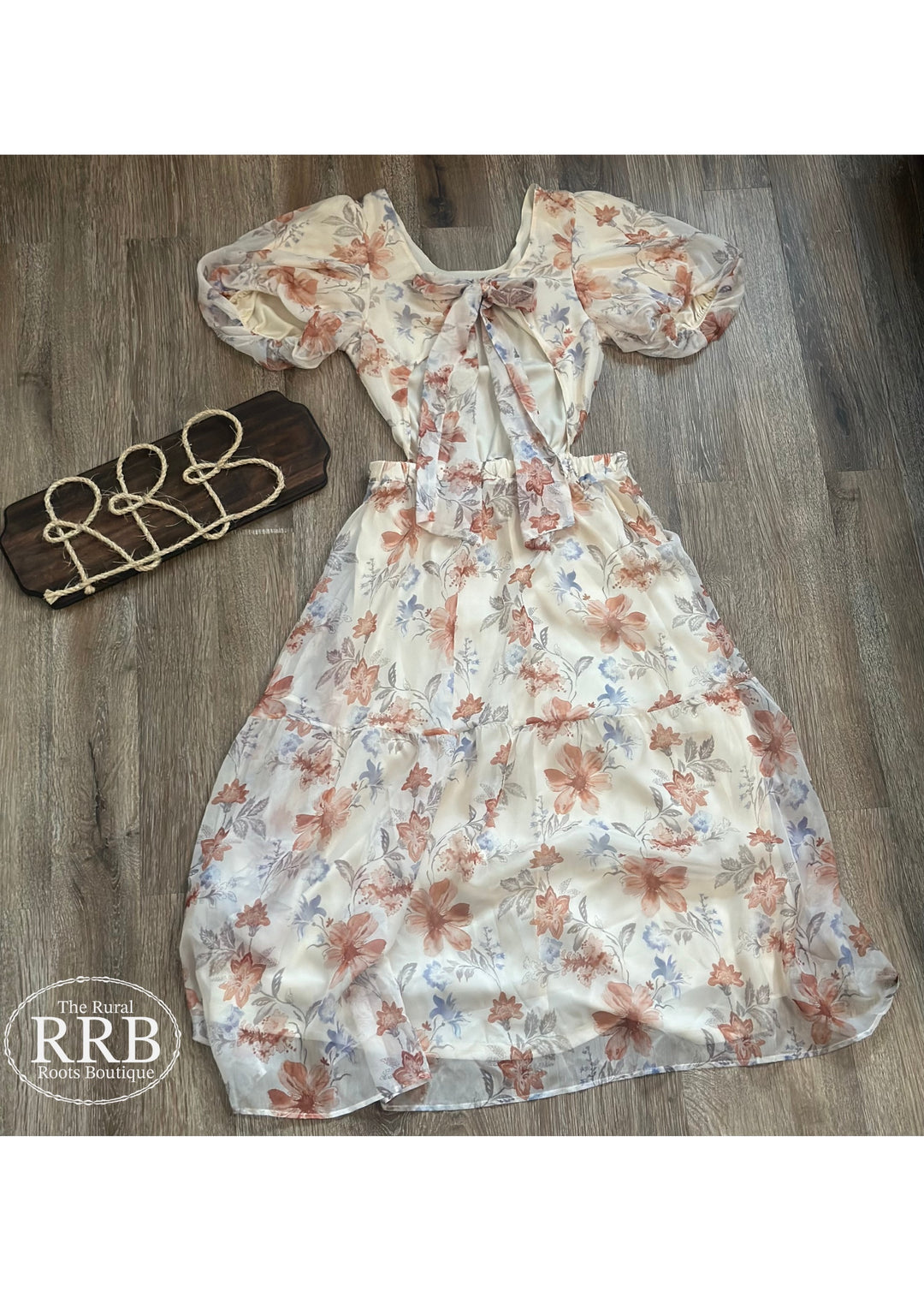 Discover The Little Prairie Dress, an elegant ivory midi dress designed with puff sleeves and a tie-back feature for a flattering fit. The open back adds a chic touch, making it ideal for summer events or casual outings. Crafted from 100% polyester, available in Small (3-5), Medium (6-8), and Large (9-11).