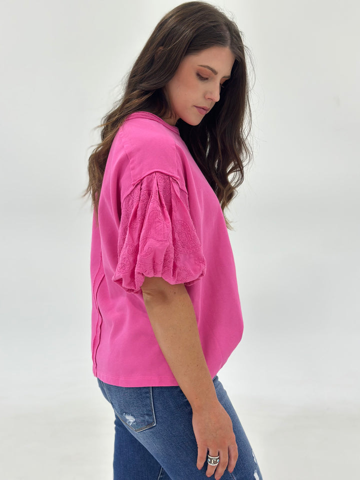 Shop The Marren – a boutique favorite women’s top in candy pink with trendy short bubble sleeves, a round neckline, and soft contrast fabric for added texture. Made from 100% cotton and designed for a flowy, relaxed fit, this short sleeve shirt is a comfortable and stylish option for warm days or layering seasons. The lightweight cotton fabric is breathable and non-restrictive, offering ease of movement and a flattering drape. Great for shoppers looking for casual pink tops, cotton flowy blouses, or puff sl