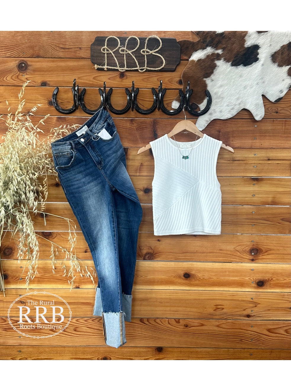 Add a touch of elegance to your wardrobe with The Emery Shirt, a sleeveless sweater tank in ivory. Featuring unique texture detailing and a rounded neckline, this top is made from a comfortable blend of 52% rayon, 29% polyester, and 19% nylon. Perfectly styled with the Laramie High Rise Cuffed Straight Jeans for a chic look.