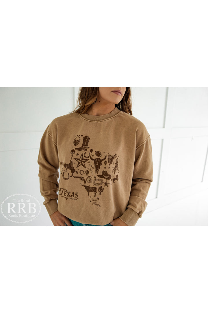 Stay stylish and warm in the Mineral Taupe Texas on My Mind Sweatshirt, featuring a relaxed fit ideal for everyday wear. This sweatshirt combines comfort with a charming Texas-themed design, making it a great addition to your casual wardrobe. Available in Small (3-5), Medium (6-8), Large (9-11), and X-Large (12-14).