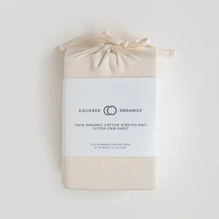Organic baby crib sheet in ivory neutral color crafted from soft breathable cotton gentle on newborn and infant skin fits standard cribs and toddler beds easy to wash, durable, and a must have practical and stylish baby bedding essential for new moms.