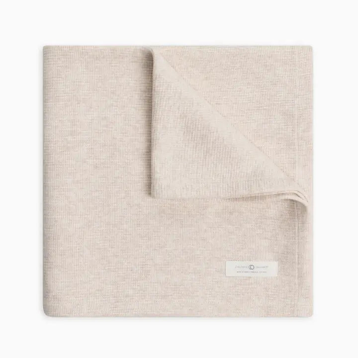 Organic waffle knit baby blanket in heather oat crafted from soft lightweight cotton gentle on baby skin ideal for swaddling, cuddling, stroller use, or naps breathable, cozy, and durable a must-have stylish and practical baby essential for newborns and infants.