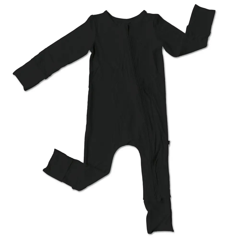 Organic bamboo footed sleeper in black with white feet crafted from sustainable bamboo viscose that is soft stretchy and breathable perfect for eco conscious parents and stylish enough for baby girls or boys to wear day or night.
