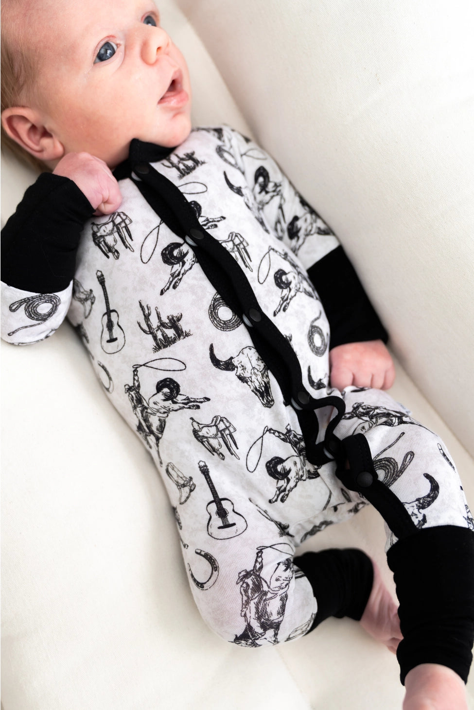 Hunter black and white bamboo baby footie with western accents crafted from soft stretchy bamboo fabric gentle on baby skin ideal for sleeping, lounging, or playtime lightweight, breathable, and durable a must-have practical and stylish baby essential for new moms.