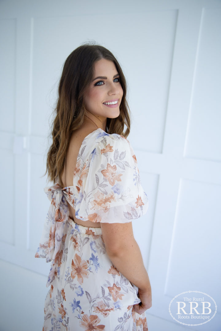 Make a statement in The Little Prairie Dress, a romantic ivory midi dress designed with puff sleeves and a stylish tie back for a flattering silhouette. The open back design adds a touch of sophistication, making it suitable for special occasions. Crafted from 100% polyester, available in Small (3-5), Medium (6-8), and Large (9-11).
