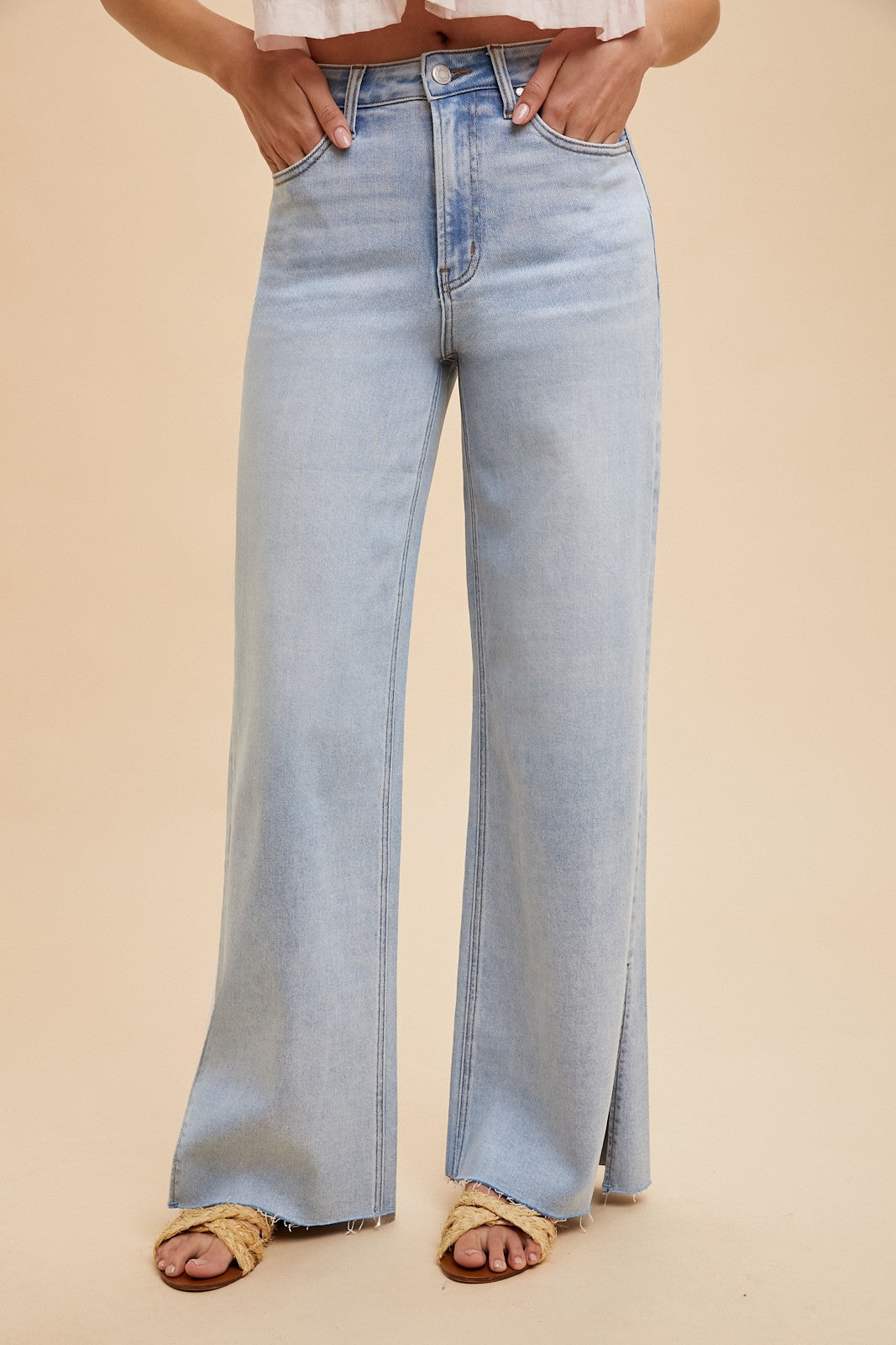The Sadie High Rise Wide Leg Jeans feature a light wash and a flattering silhouette with a modern wide leg cut. Designed with subtle side slits at the hem, these jeans offer both style and comfort thanks to their stretchy denim blend of 92% cotton, 6% polyester, and 2% spandex. The high rise waistline provides a secure, contoured fit, making them a versatile staple for any casual or dressed-up look.