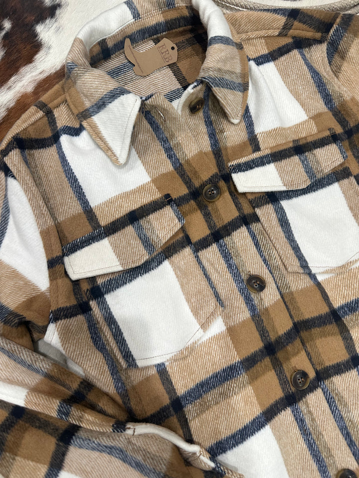 The Athens Camel Plaid Flannel Jacket features a relaxed, oversized fit with classic details, including a collared neckline, chest flap pockets, and convenient side pockets. Crafted from cozy flannel fabric, this jacket is perfect for layering on cooler days. Available in sizes small (3-5), medium (6-8), and large (9-11); if between sizes, sizing down is recommended. Comparable to shackets by Carhartt and Abercrombie, this jacket combines rugged style with warmth and comfort for everyday wear.