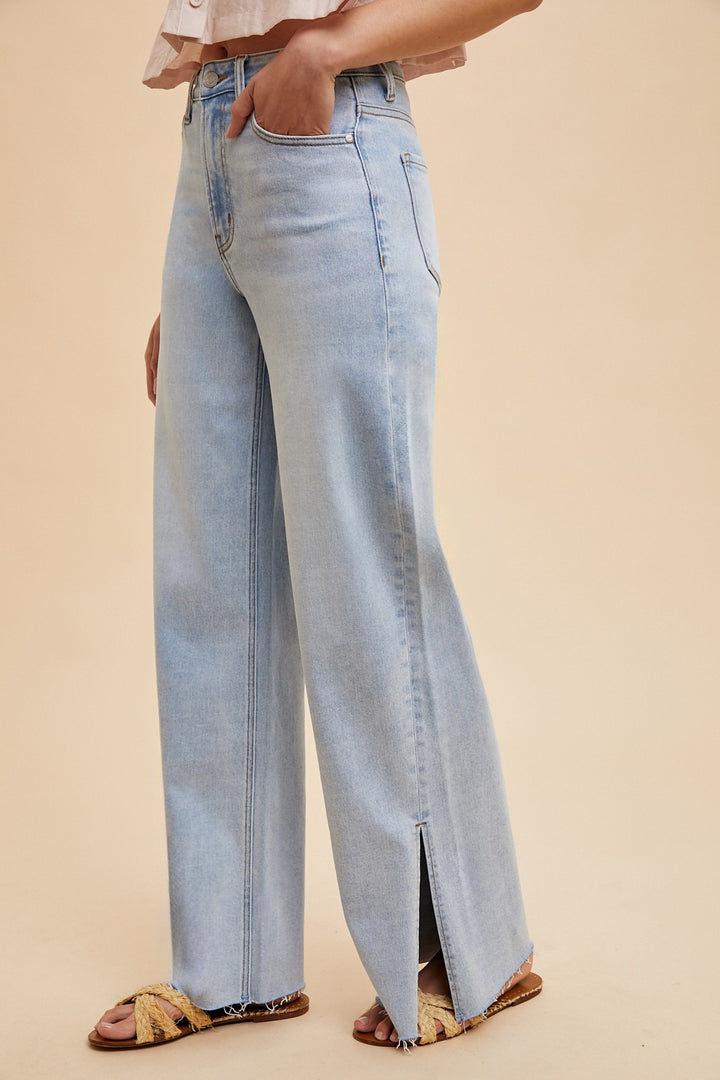 The Sadie High Rise Wide Leg Jeans feature a light wash and a flattering silhouette with a modern wide leg cut. Designed with subtle side slits at the hem, these jeans offer both style and comfort thanks to their stretchy denim blend of 92% cotton, 6% polyester, and 2% spandex. The high rise waistline provides a secure, contoured fit, making them a versatile staple for any casual or dressed-up look.