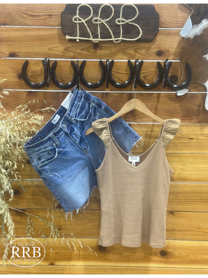The Ashland Ruffle Tank Top in a warm mocha shade is crafted from 100% breathable cotton, offering a lightweight and comfortable feel for casual, everyday style. This women’s sleeveless blouse features delicate ruffle accents, adding a touch of femininity to a relaxed fit. Available in sizes small (2-4), medium (6-8), and large (8-10), this top is a versatile wardrobe staple, perfect for layering or wearing solo, and is comparable to tops from Madewell and Aerie.