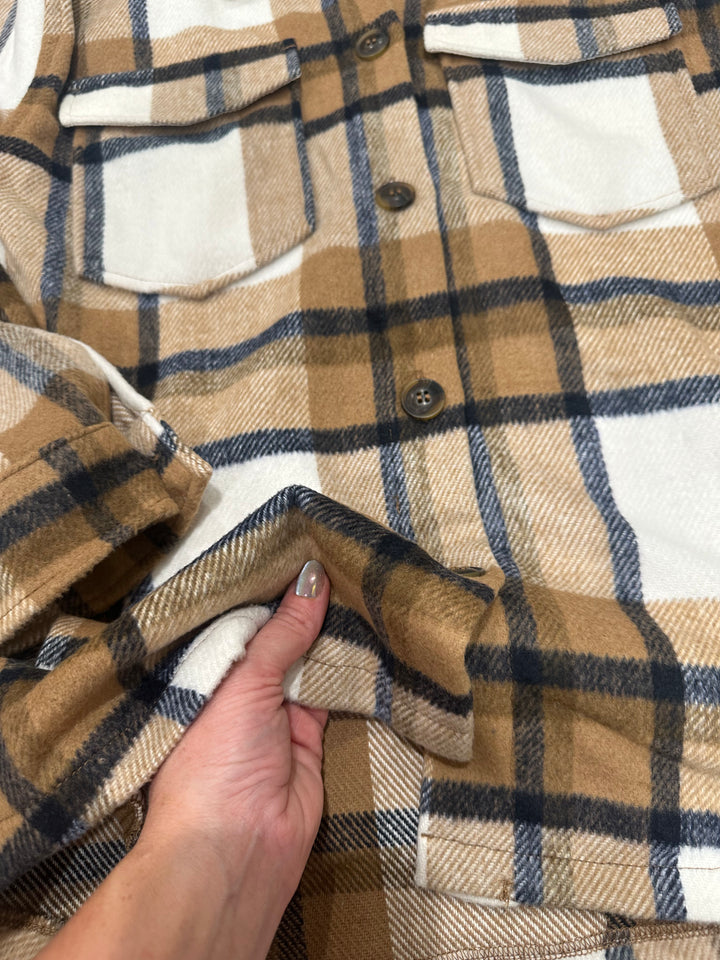 The Athens Camel Plaid Flannel Jacket features a relaxed, oversized fit with classic details, including a collared neckline, chest flap pockets, and convenient side pockets. Crafted from cozy flannel fabric, this jacket is perfect for layering on cooler days. Available in sizes small (3-5), medium (6-8), and large (9-11); if between sizes, sizing down is recommended. Comparable to shackets by Carhartt and Abercrombie, this jacket combines rugged style with warmth and comfort for everyday wear.