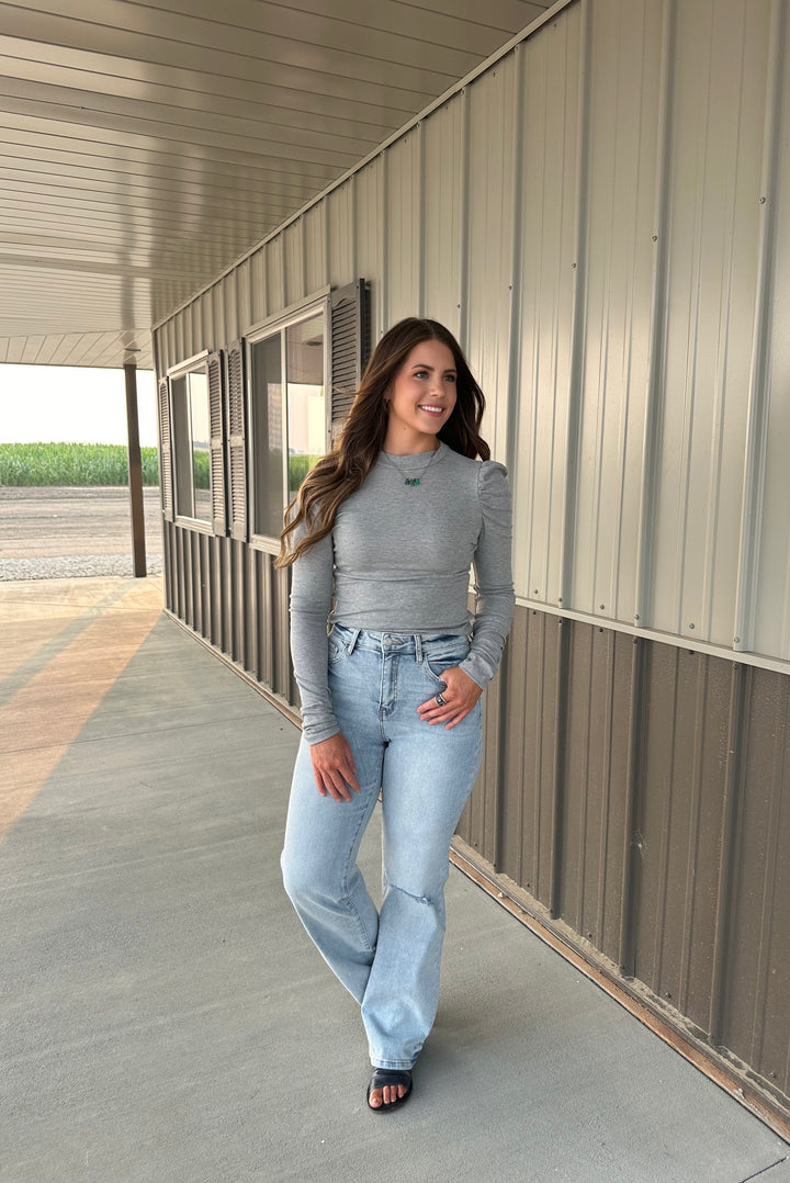 Introducing The Burwell Ripped Puff Sleeve Top in grey, featuring trendy puff sleeves for a stylish touch. This comfortable top is crafted from a soft blend of 60% polyester, 35% rayon, and 5% spandex, ensuring a flattering fit for everyday wear. Perfect for pairing with jeans or skirts, this versatile piece adds a fashionable flair to any outfit, making it a must-have for any fashionista.