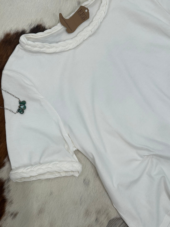 Elevate your casual wardrobe with The Chappell Short Sleeve Top in crisp White. This chic top features unique braided knot trim on the neckline and sleeves, adding a touch of flair to your outfit. Crafted from 95% cotton and 5% spandex for a comfortable fit, it's available in small, medium, and large, making it a perfect choice for any occasion.