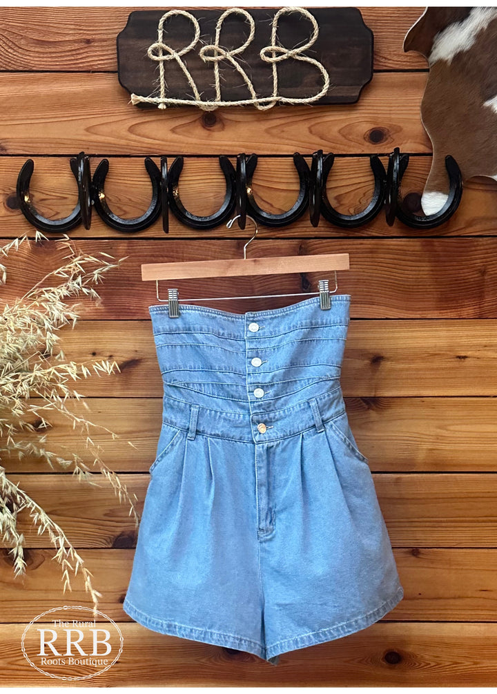 Explore The Cheyenne dress in Light Indigo, featuring a stylish strapless neckline, button-down front, and convenient zipper closure. This dress includes side pockets and a smocked back for added comfort and flexibility. Available in small, medium, and large sizes, perfect for any occasion.