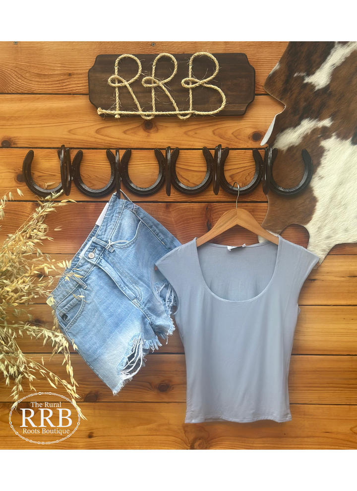 Experience ultimate comfort with The Dusty Fitted Shirt in dusty blue. This sleeveless top features a flattering scoop neckline and is crafted from a buttery soft blend of 94% rayon and 6% spandex. Ideal for layering or wearing on its own, this shirt offers a stylish yet comfortable fit for any occasion.