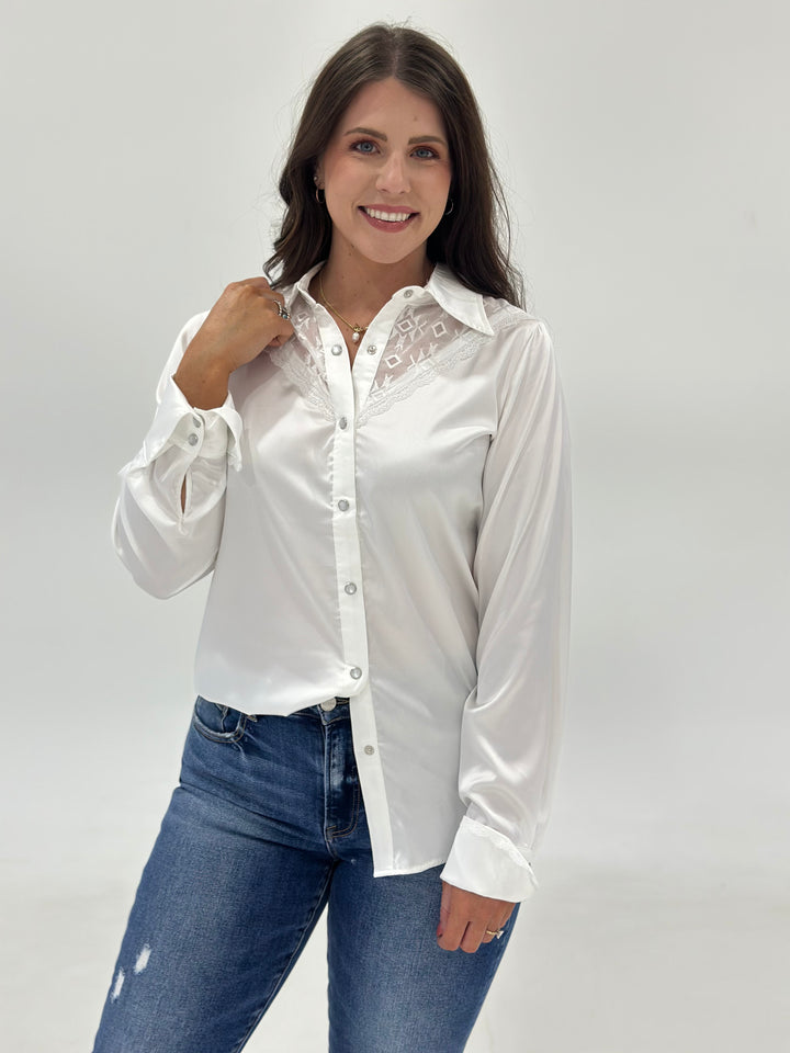 The Elsie Aztec Lace Button Down Shirt combines long sleeves, pearl snap closures, and a contemporary fit. Made from luxurious silk with an Aztec lace design for a chic, sophisticated look. Available in Small (3-5), Medium (6-8), and Large (9-11).