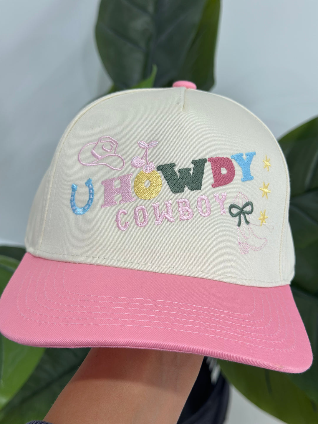  The Howdy Cowboy Pink/Natural Canvas Cap combines vibrant embroidery with an adjustable snapback for a comfortable and stylish fit. A must-have accessory for cowboy spirit.