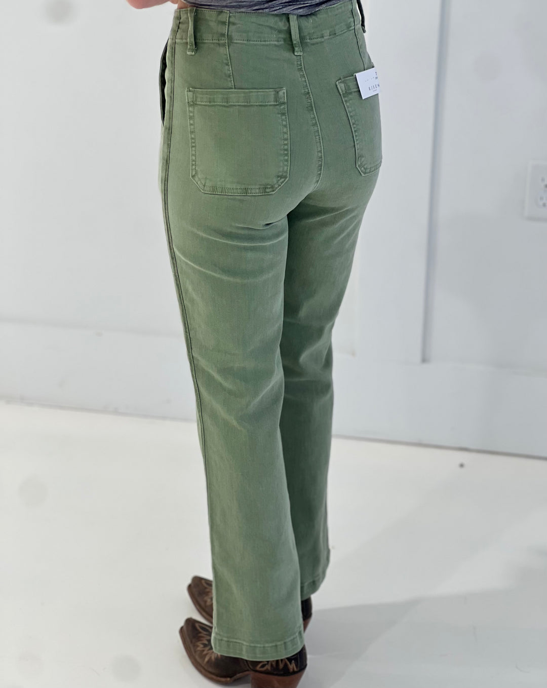 Green pants worn by a person on a white background