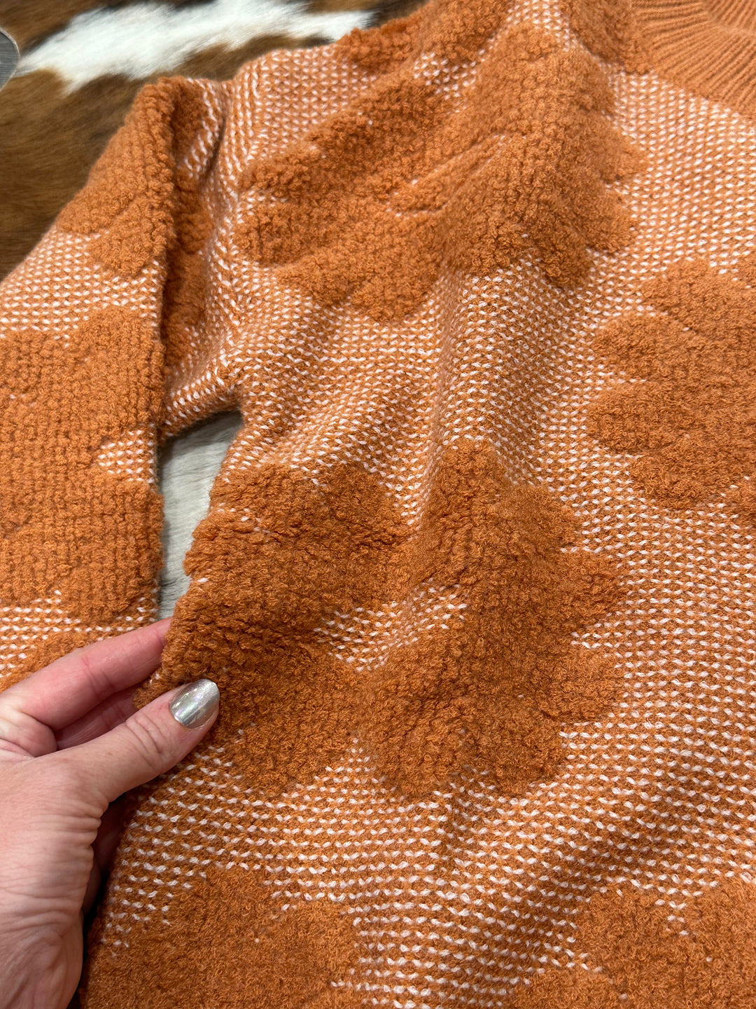 Warm and cozy Marlow rust-colored floral knit sweater with a relaxed fit, perfect for cooler days. Available in sizes Small (3-5), Medium (6-8), and Large (9-11), this sweater makes a versatile addition to any wardrobe. Comparable to cozy knits from Urban Outfitters and Everlane.