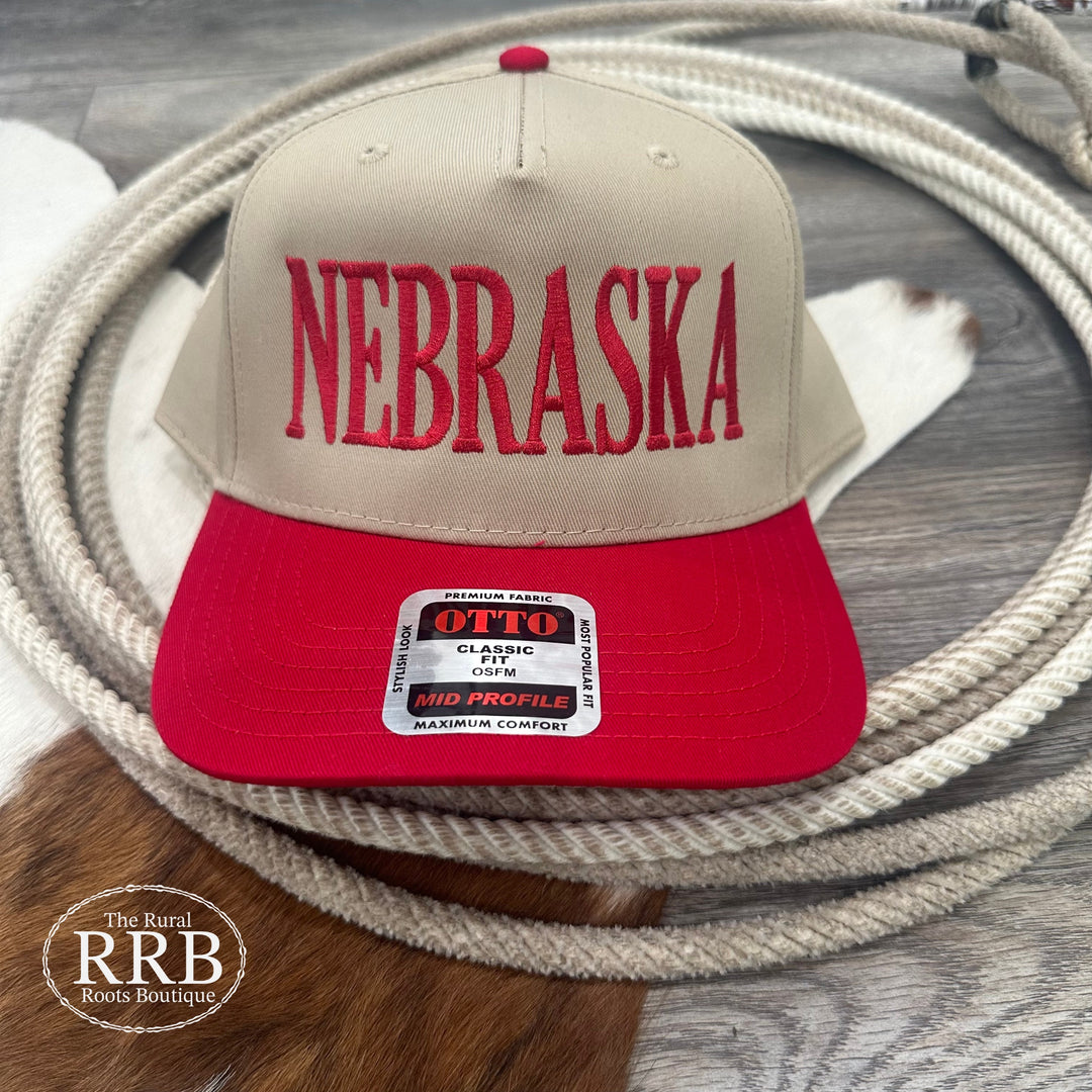 Classic Nebraska cap in tan and red with an adjustable snapback closure for a custom fit. This versatile cap adds a sporty touch to any look, perfect for fans and casual wearers alike.