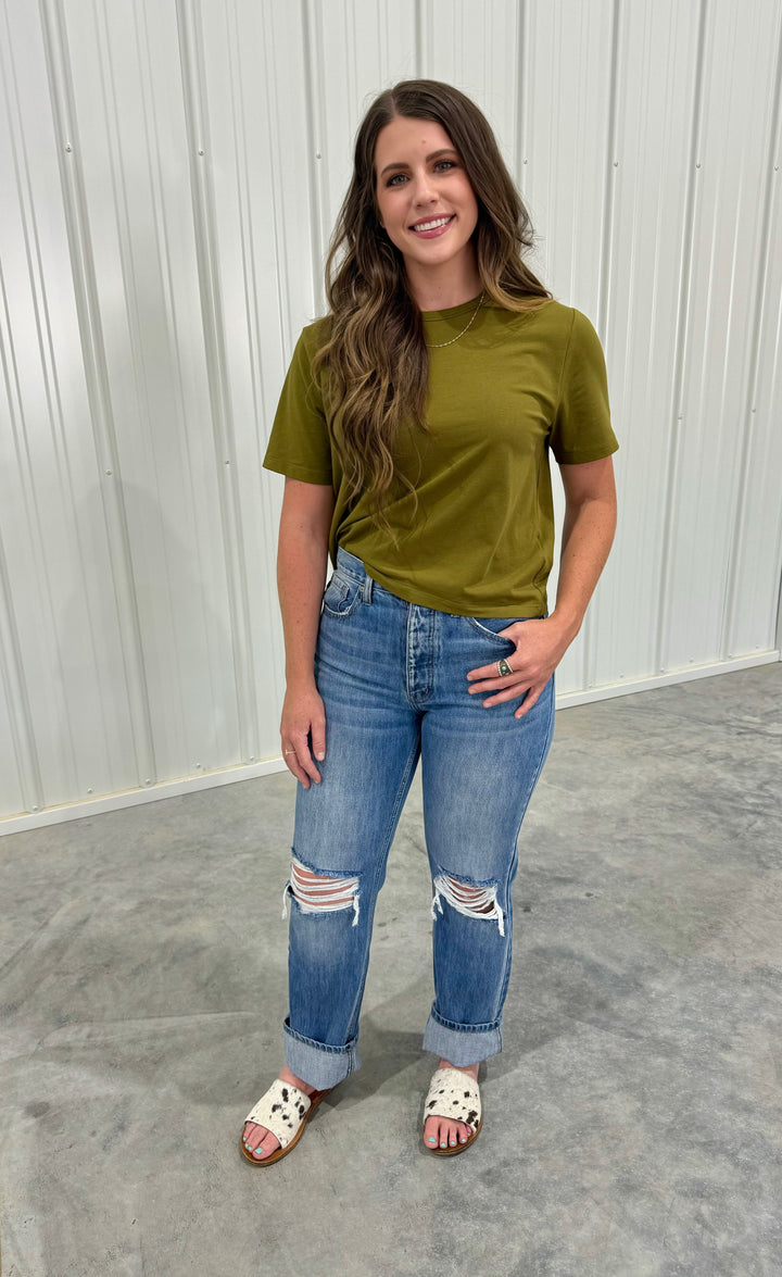 Chic The Oliver crop top in olive, designed as a mom basic tee with a relaxed boxy fit. Composed of 95% organic cotton and 5% spandex, it offers comfort and style. This top tends to run small, so sizing up is advised if you're between sizes. Available in X-Small (0-2) to X-Large (12-14) for a versatile wardrobe addition.
