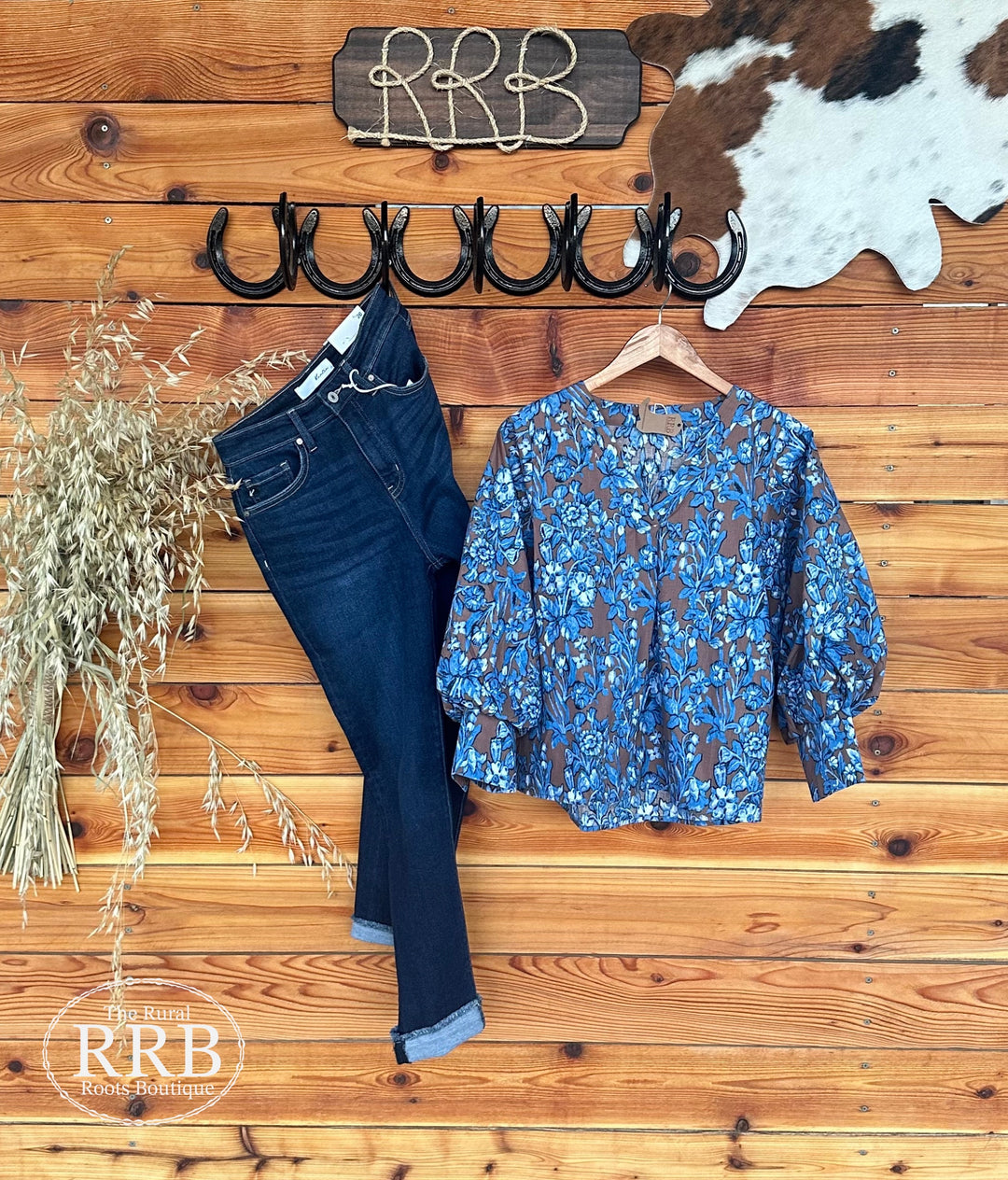 Step into style with The Rowan top in mocha and blue floral print. Featuring a flattering V-neck, front pleating, and three-quarter balloon sleeves with wide band cuffs, this lightweight, non-sheer top offers a flowy fit. Made from 100% cotton, it's perfect for any occasion. Available in Small (3-5), Medium (6-8), and Large (9-11).