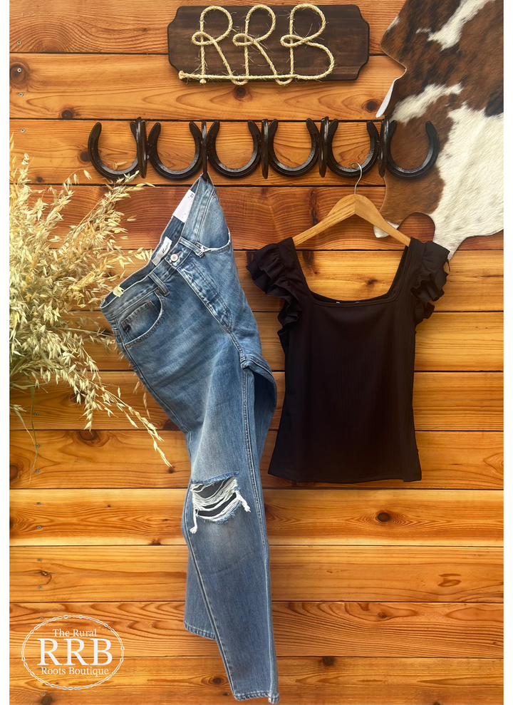 Elevate your style with The Shawnee, a chic black ribbed knit top featuring a flattering square neckline and playful ruffled sleeves. Available in sizes Small (2-4), Medium (6-8), and Large (8-10), this versatile top is perfect for dressing up or down, making it an essential addition to your wardrobe.