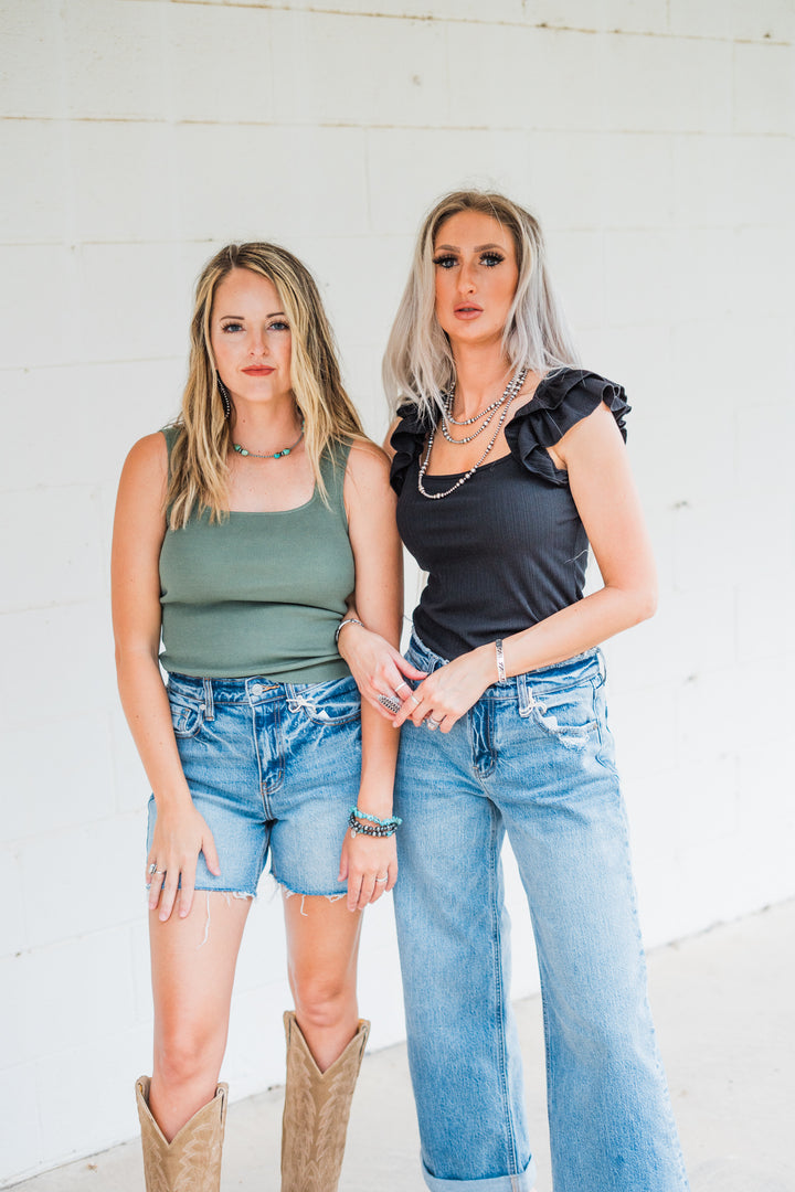 Make a statement with The Shawnee, a trendy black ribbed knit top featuring a square neckline and eye-catching ruffled sleeves. Available in Small (2-4), Medium (6-8), and Large (8-10), this top combines comfort and style, making it a perfect choice for any occasion.