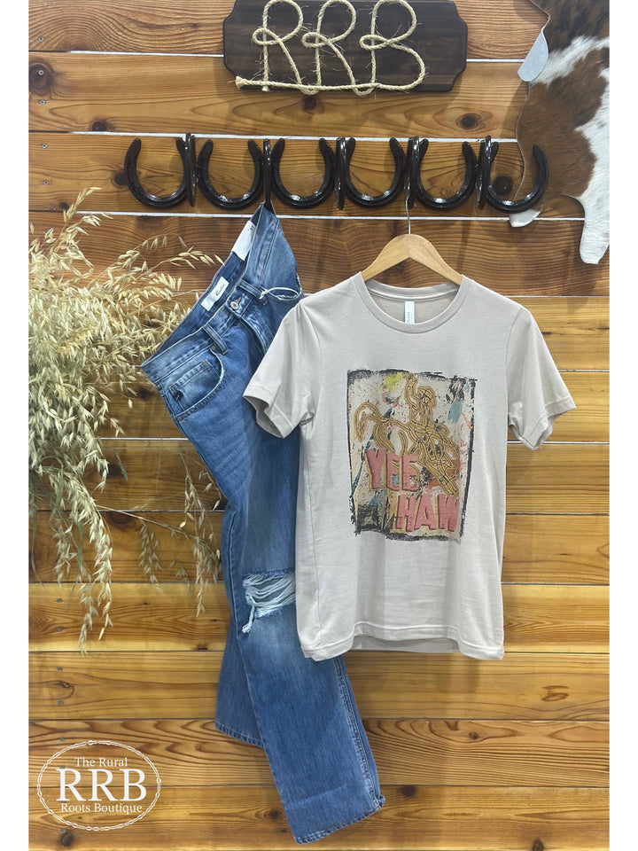Embrace your western spirit with The Splatter Cowboy Yeehaw Tee in a stylish belle tan color. This unisex-fitting t-shirt is designed for comfort and versatility, making it a perfect choice for casual outings or layering. Available in sizes X-Small (0-2), Small (3-5), Medium (6-8), Large (9-11), and X-Large (12-14), it's the ideal addition to any cowgirl or cowboy's wardrobe.