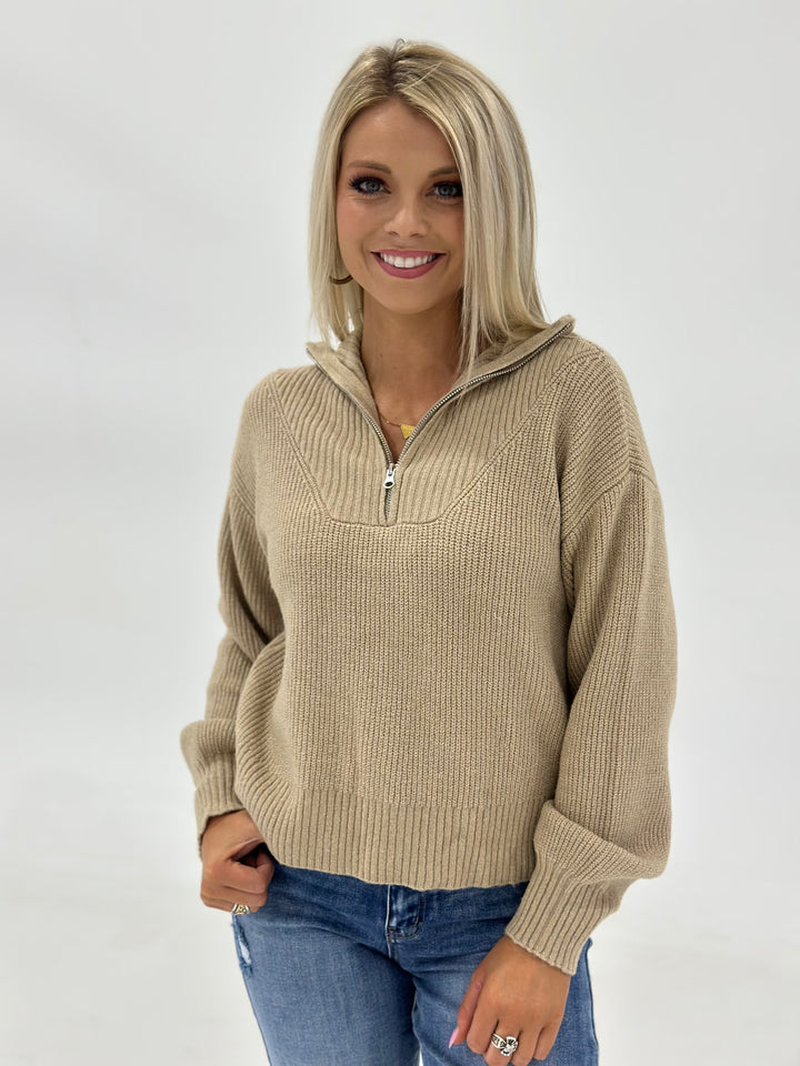 The Truett Mock Neck Half Zip in Khaki features a sleek mock neck design, long sleeves, and a lightweight fabric blend of 82% Polyester, 15% Acrylic, and 3% Spandex for comfort and style. Available in Small (3-5), Medium (6-8), and Large (9-11).