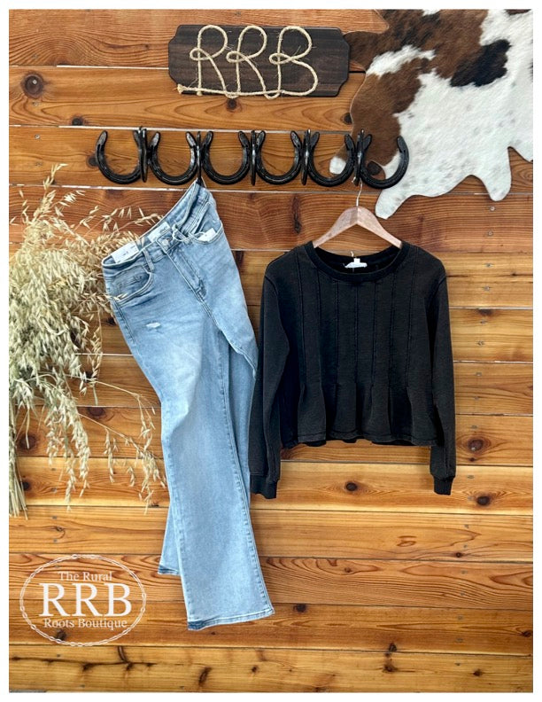 Embrace effortless style with The Waco Snow Washed Long Sleeve Top in Ash Black. This trendy top features a rounded neckline and unique seams with pleats for added detail. Designed with banded cuffs and a slightly shorter length, it offers a flattering fit. Made from 85% cotton and 15% polyester, it's both comfortable and chic. Pair it with the Camden 90's Vintage Super High Rise Flare Jeans for a complete look.