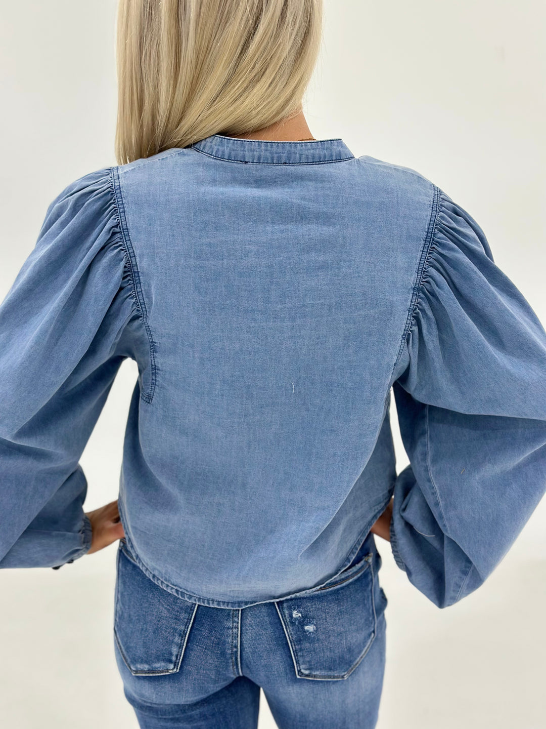 The Zara is a denim button down shirt for women featuring long sleeves and bold volume sleeves for added shape and flair. Designed for the fashion lover who wants a classic with a little attitude, this top pairs easily with jeans, skirts, or leggings. The structured fabric makes it ideal for layering over basics, and the voluminous sleeves create a standout silhouette without being over the top. If you're looking for a women’s boutique denim shirt, a long sleeve button up with style, or a western-inspired s