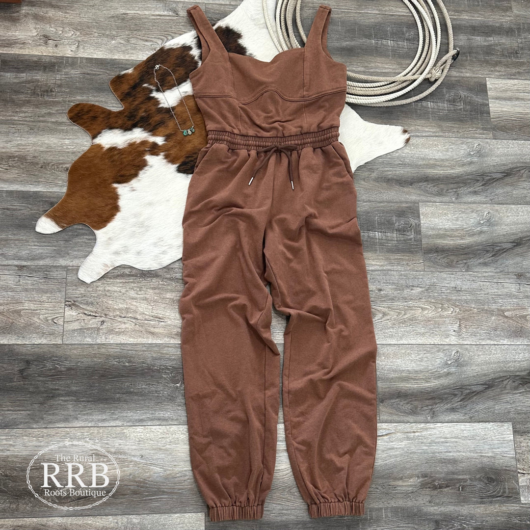 Step into style with The Waylon Sleeveless Square Neckline Jumpsuit in chocolate. Designed with an adjustable drawstring waist and elastic ankle cuffs, this jumpsuit combines comfort with a sleek silhouette. Featuring handy side pockets and made from a soft blend of 62% polyester, 33.4% cotton, and 4.6% spandex, it’s perfect for any occasion. Shown with the Kingman Turquoise Teardrop Necklace, this jumpsuit is available in Small (2-4), Medium (6-8), and Large (9-11).