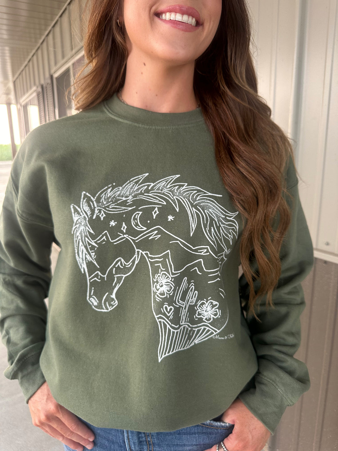 Unleash your adventurous spirit with The Wild Horse Tee in military green. Crafted from a soft 50/50 cotton-polyester blend, this unisex shirt offers a relaxed fit. Available in sizes Small (3-5), Medium (6-8), Large (9-11), and X-Large (12-14), it's a versatile addition to your wardrobe.