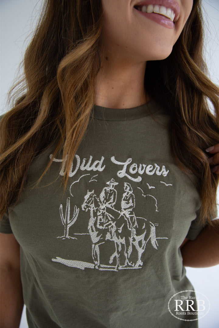 Embrace nature with The Wild Lovers Tee in olive green, adorned with cream thread hand embroidery. This unisex shirt offers a comfortable fit, crafted from a premium cotton blend. Available in sizes Small (3-5), Medium (6-8), Large (9-11), and X-Large (12-14), it’s an essential for wild souls.