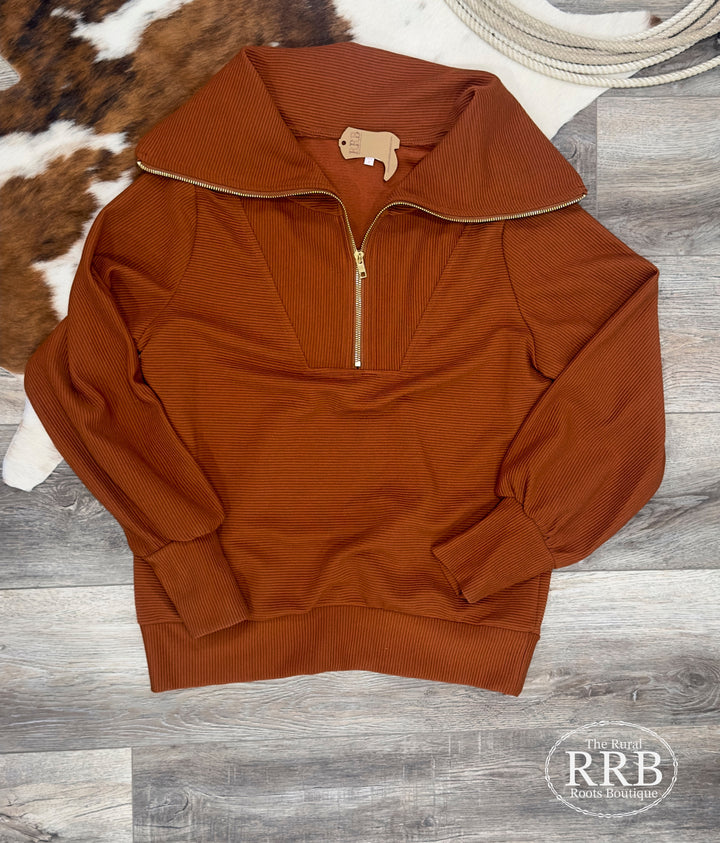 Introducing The Winona collared pullover in camel, designed for ultimate comfort and style. This relaxed-fit pullover features a convenient front zipper and long sleeves, made from 95% polyester and 5% spandex. Available in Small, Medium, and Large sizes, it's a must-have for your wardrobe.