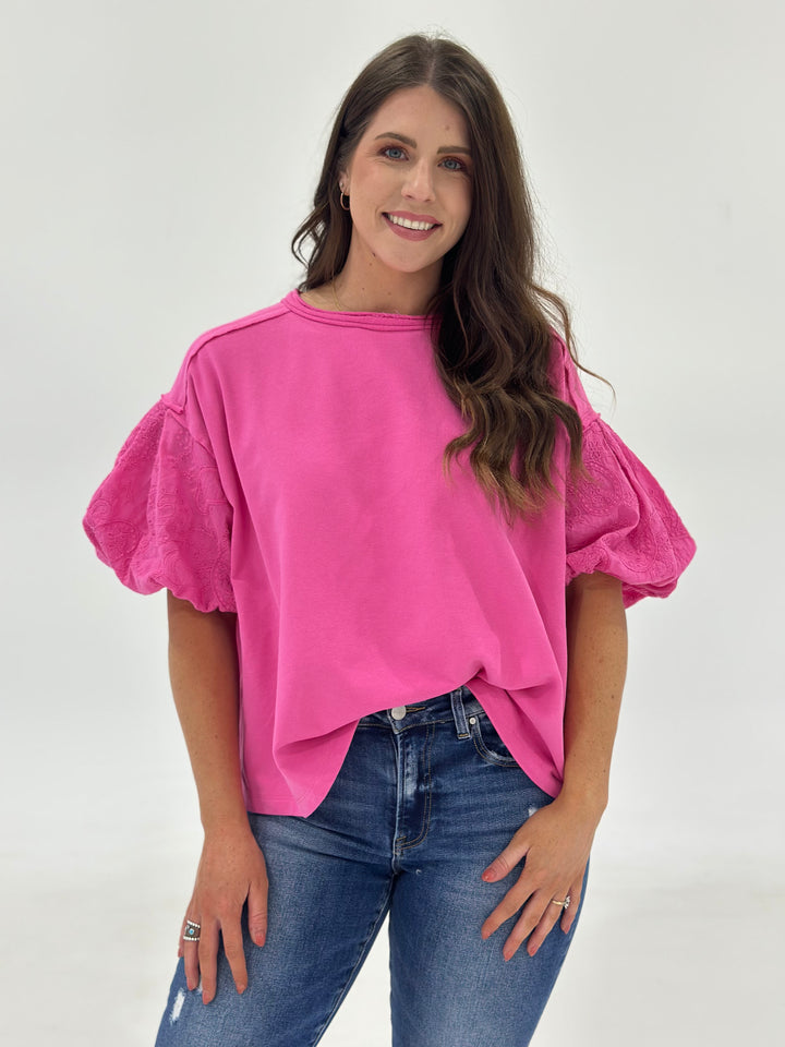 Say hello to your new favorite everyday blouse: The Marren in a vibrant candy pink shade. This women’s flowy cotton top is designed with bubble short sleeves, a comfy round neck, and a relaxed silhouette that skims just right—effortless, breezy, and easy to style with your favorite jeans or shorts. The contrast fabric gives it just enough texture to stand out, and the 100% cotton construction makes it cool, breathable, and non-clingy. If you’re in between sizes, trust us—go down one for a more tailored vibe