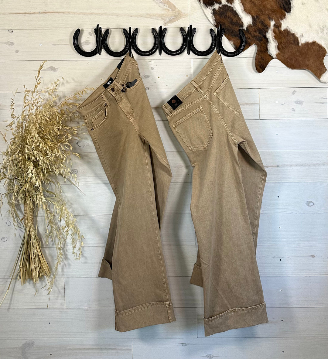 Shop the Woodstock Cuffed High Rise Palazzo Jeans in Dark Khaki. These wide-leg jeans feature a flattering high-rise fit, chic cuffed hem, and a sophisticated palazzo style. Perfect for casual or dressy looks, crafted from a durable cotton blend. Non-stretch denim; size up if in between sizes for the best fit.