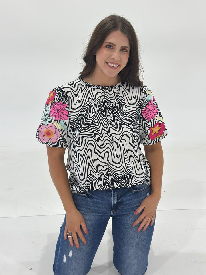 Make a statement with The Cali Top, a bold yet versatile white and black blouse featuring intricate designs for a unique, fashion-forward look. Crafted from a soft, breathable fabric, this long-sleeve top offers a comfortable fit with a touch of stretch. Perfect for dressing up with black denim and boots or keeping it casual with distressed jeans, The Cali Top is the ideal blend of western charm and modern style. Whether you’re heading to a country concert, brunch with friends, or a stylish night out, this 